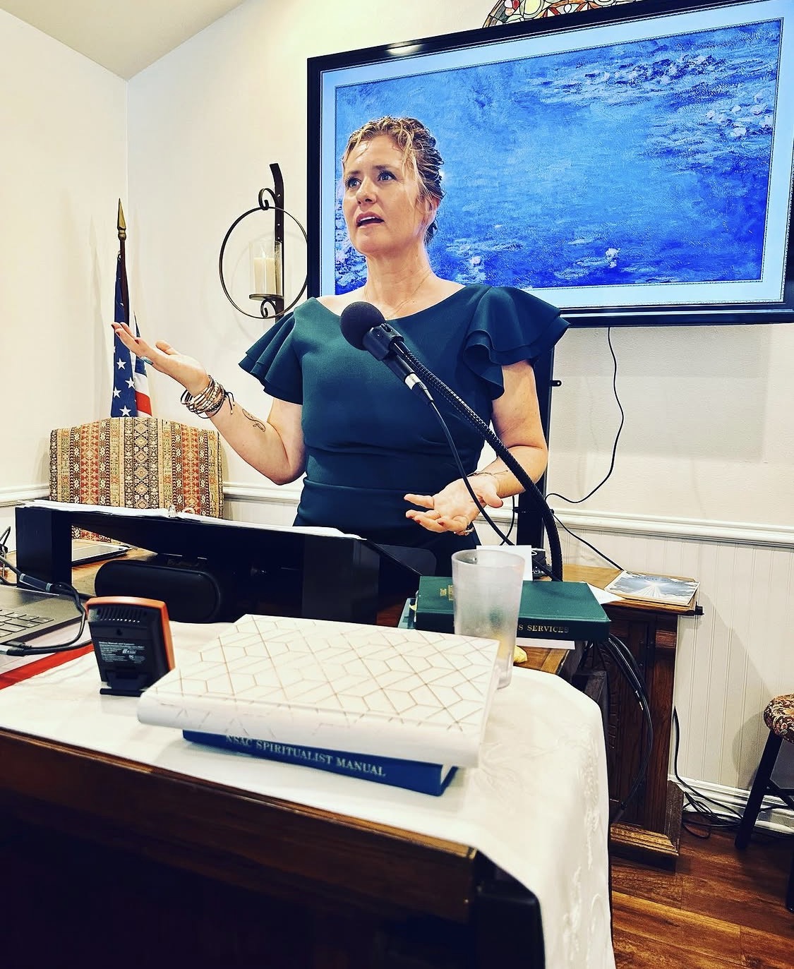 Alicia Journey speaking at a lectern during a spiritual gathering