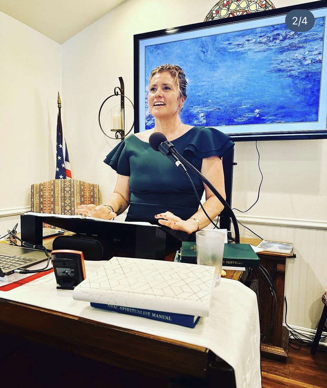 Alicia Journey speaking into a microphone and gesturing during a live event